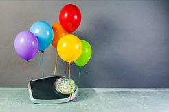 Balloons lift a scale.